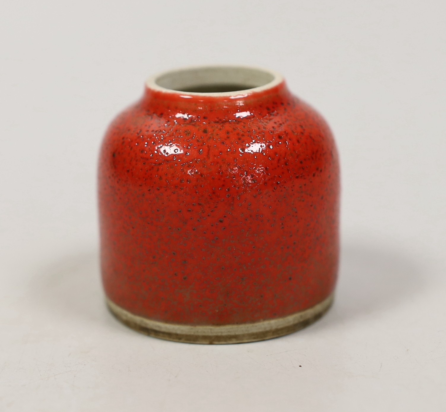 A Chinese red glazed brushwasher. 6cm tall